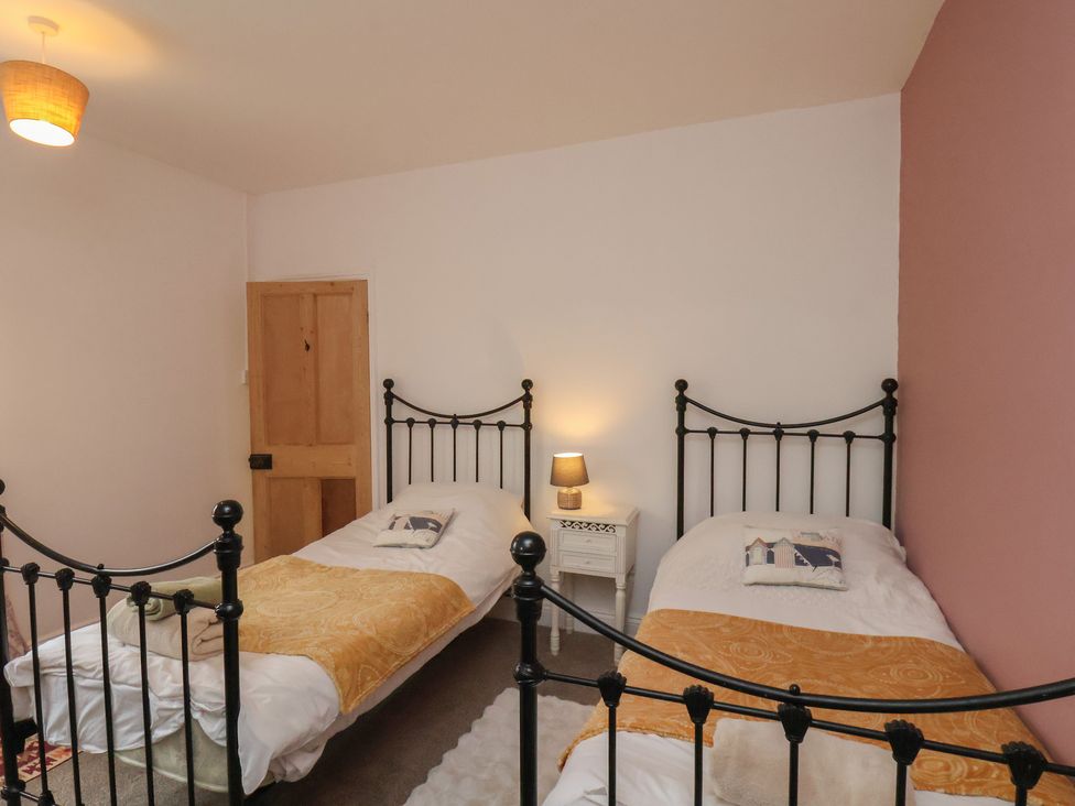 A bedroom with two single beds and a nightstand at The Manse in Whitby
