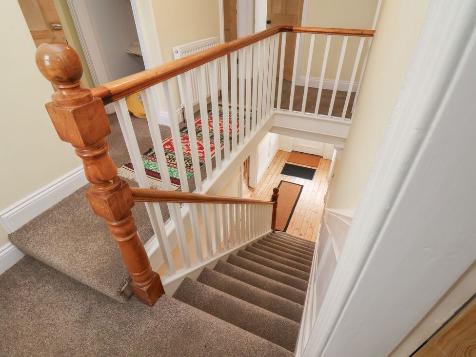 A staircase with a handrail and wooden door at The Manse in Whitby