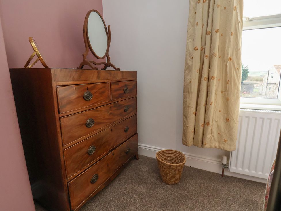 A bedroom with a dresser and mirror at The Manse in Whitby