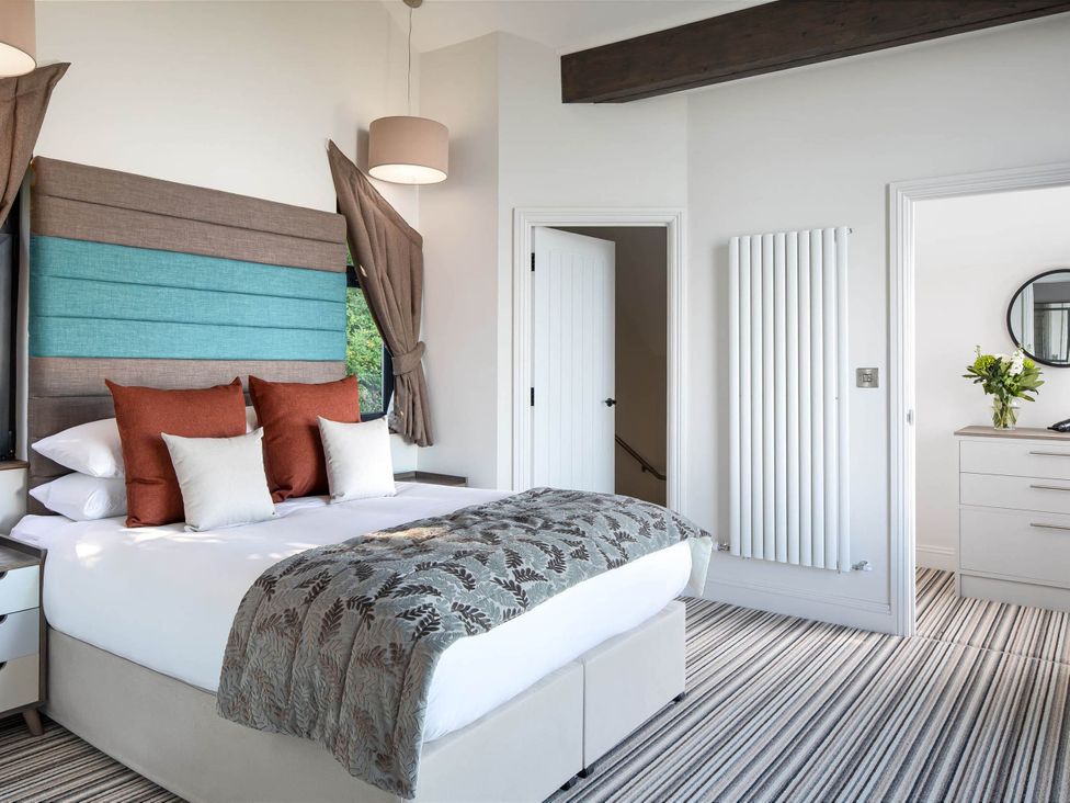 A bedroom with a bed and wardrobe at Ferry Hills in Laugharne