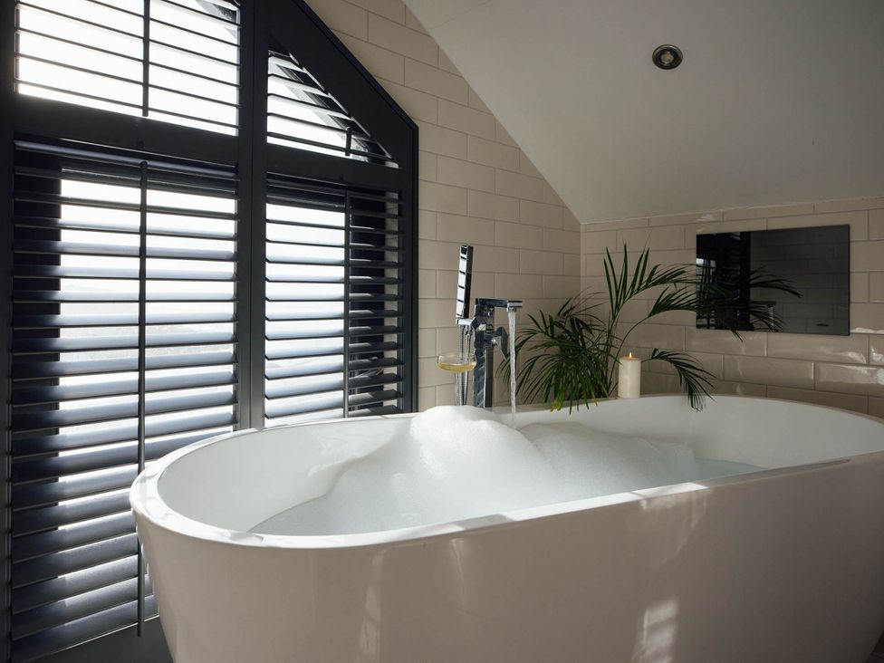 A bathroom with a bathtub near a window at Ferry Hills in Laugharne