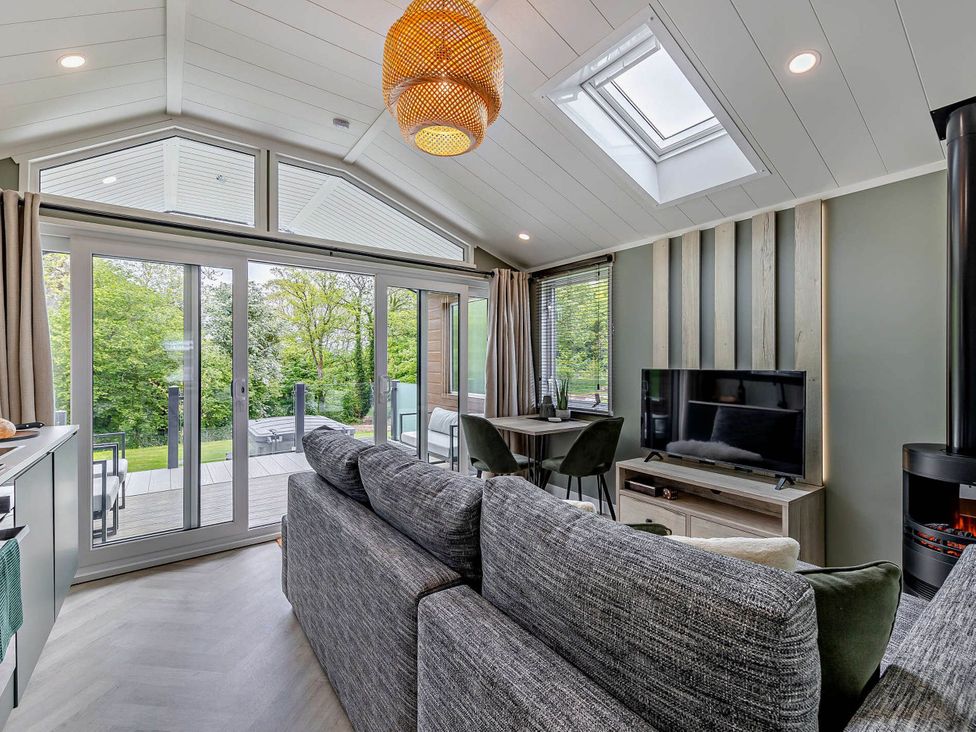 A living room with a sofa and dining area at Prion Spa, Llandyrnog
