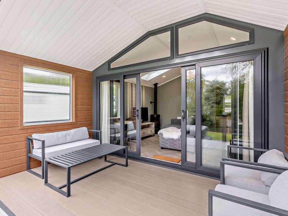 A conservatory with seating and an open view at Prion Spa in Llandyrnog