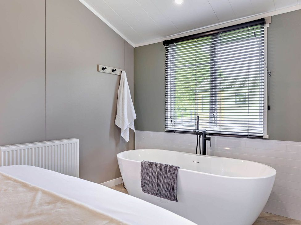 A bathroom with a bathtub and towel at Prion Spa in Llandyrnog