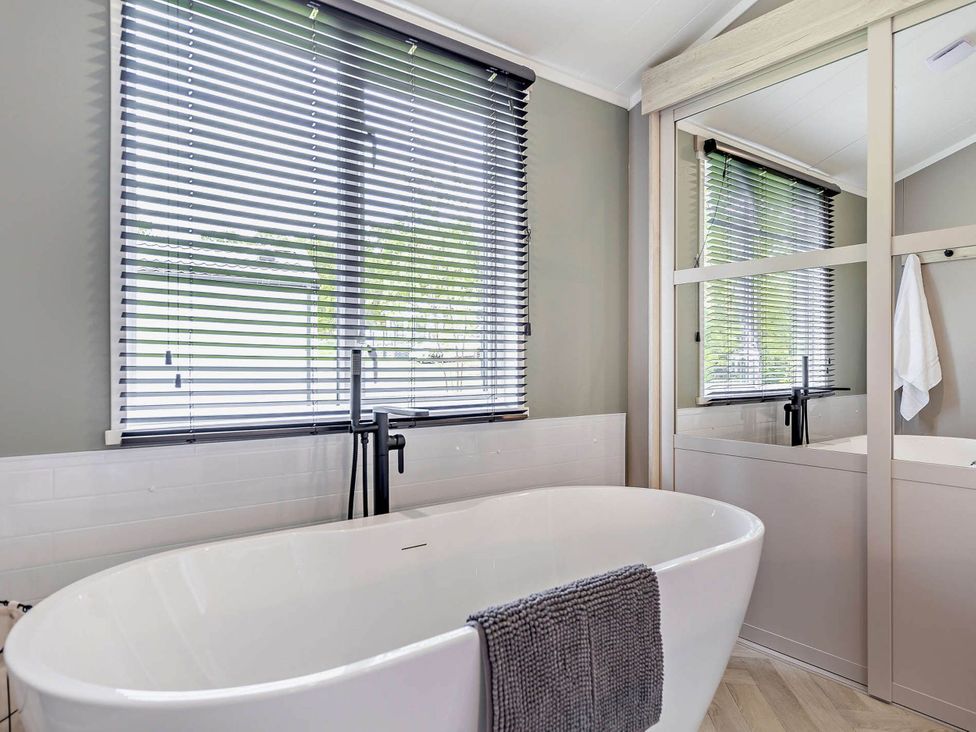 A bathroom with a bathtub and sink at Prion Spa in Llandyrnog