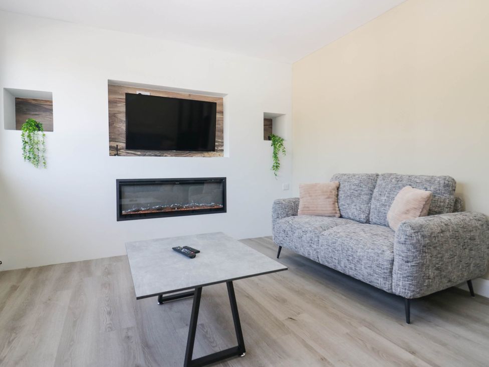 A living room with a sofa and a television mounted on the wall at Aqueduct Residence in Lancaster
