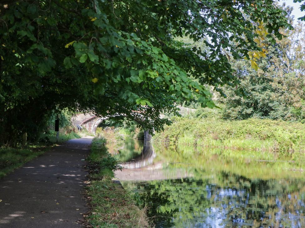 A path beside a canal with trees and a bridge at Aqueduct Residence in Lancaster