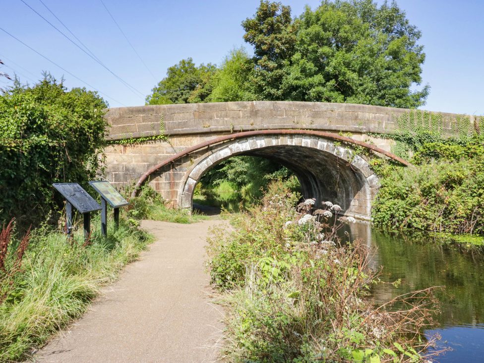 A stone bridge over a river with information signs at Aqueduct Residence in Lancaster
