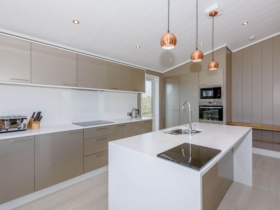 A kitchen with cabinets and appliances at Darwin Retreat in Wigton