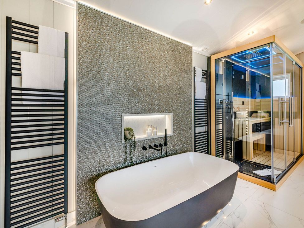 A bathroom with a bathtub and shower enclosure at The Sheraton Retreat in Wigton