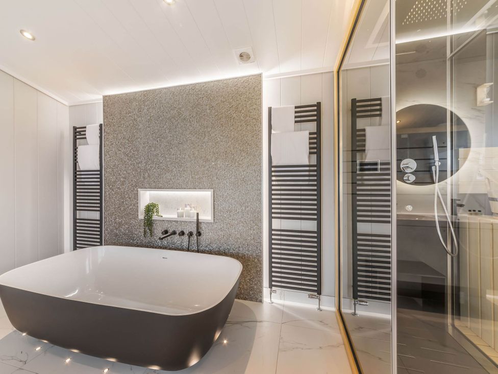 A bathroom with a bathtub and shower area at The Sheraton Retreat in Wigton