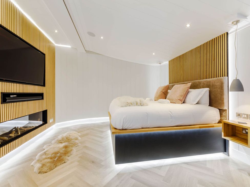 A bedroom with a bed and television at The Sheraton Retreat in Wigton