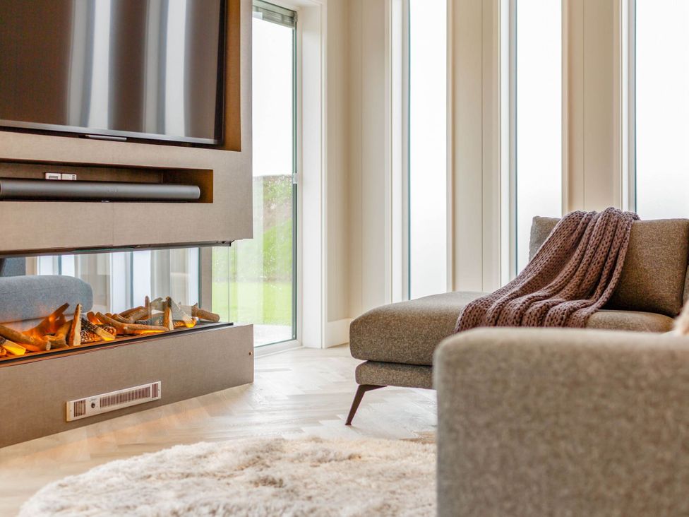 A living room with a television and a fireplace at The Sheraton Retreat in Wigton