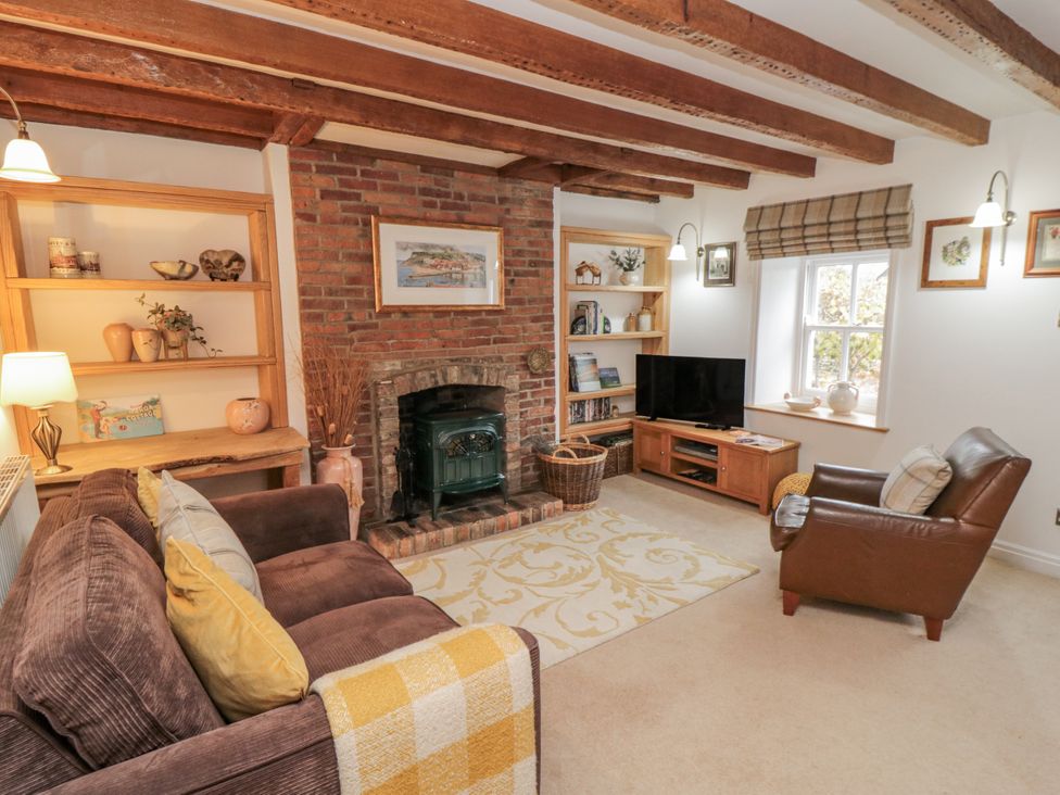 A living room with a fireplace and furniture at 21 High Street in Scarborough