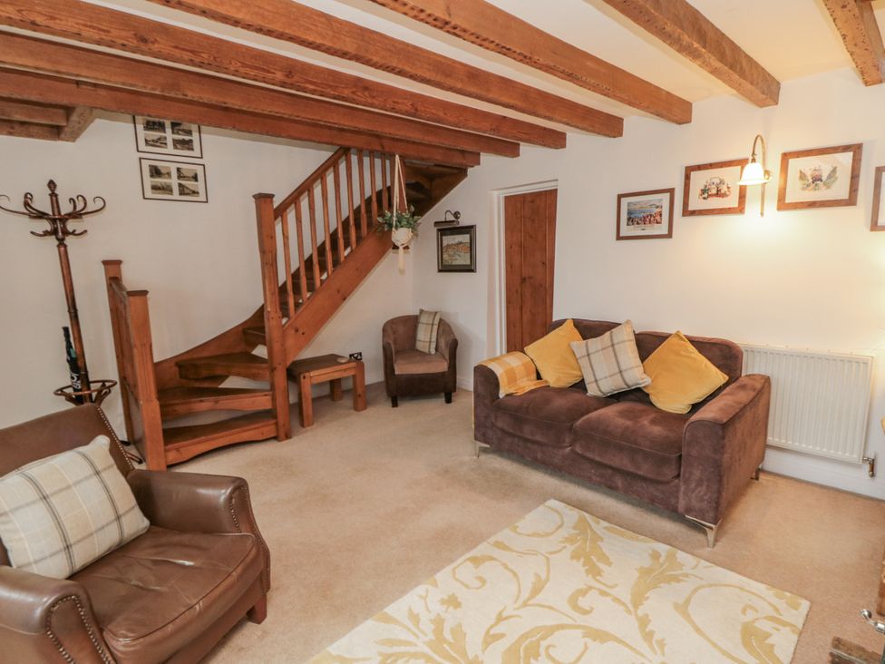 A living room with seating and staircase at 21 High Street in Scarborough