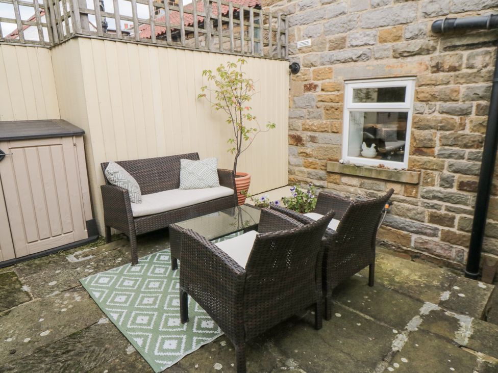An outdoor seating area with a glass table and chairs at 21 High Street in Scarborough