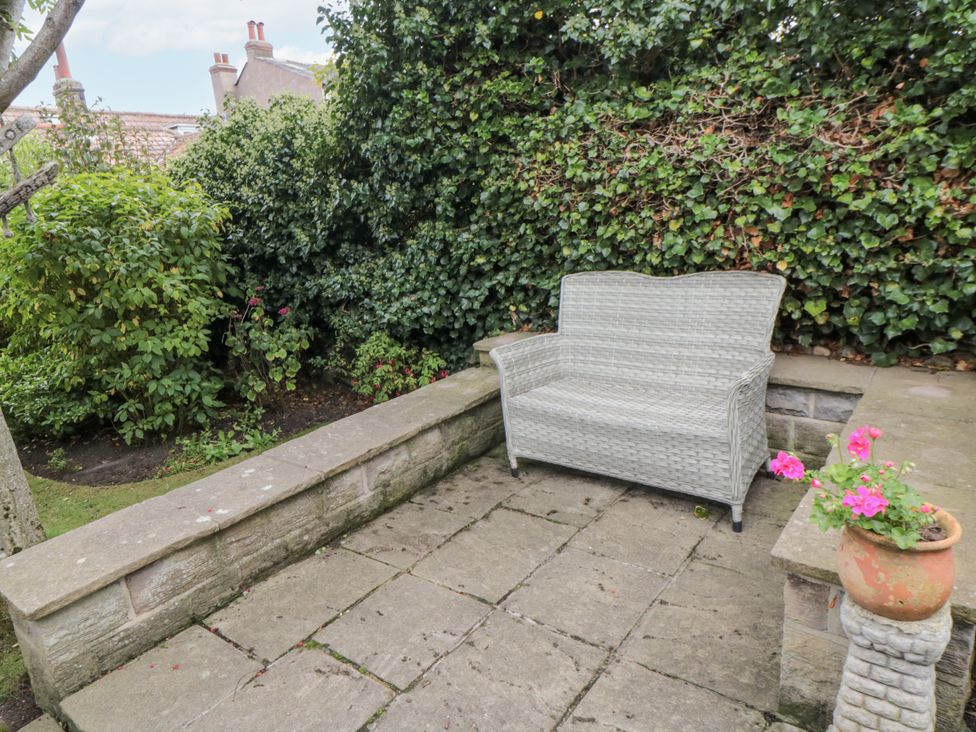 A garden with a bench and flower pot at 21 High Street Scarborough