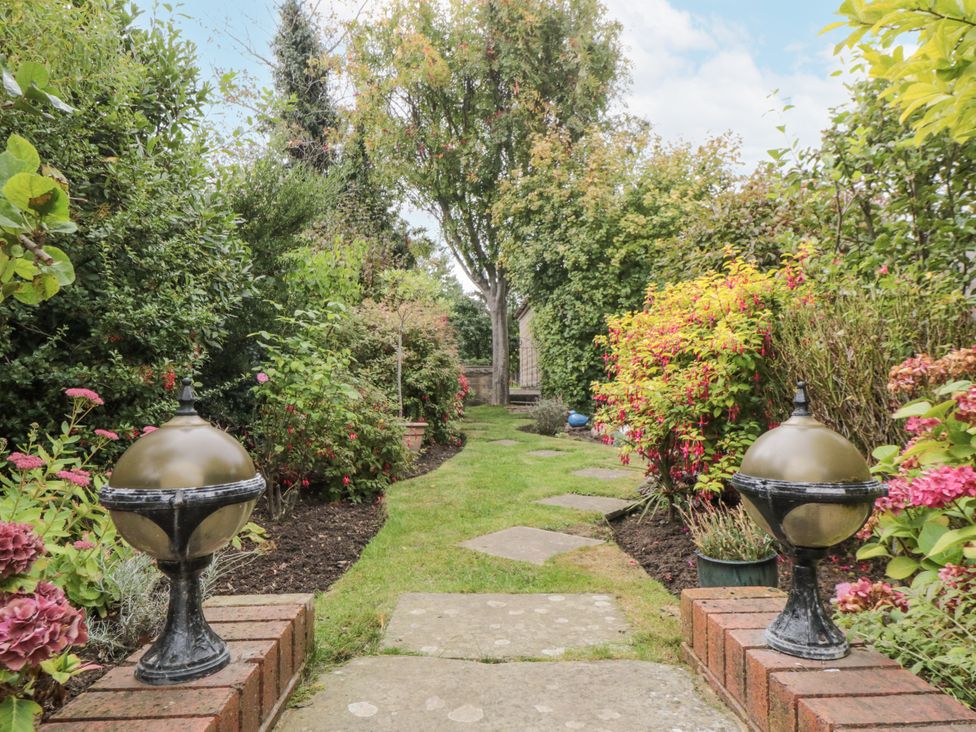 A garden with a pathway and planters at 21 High Street Scarborough