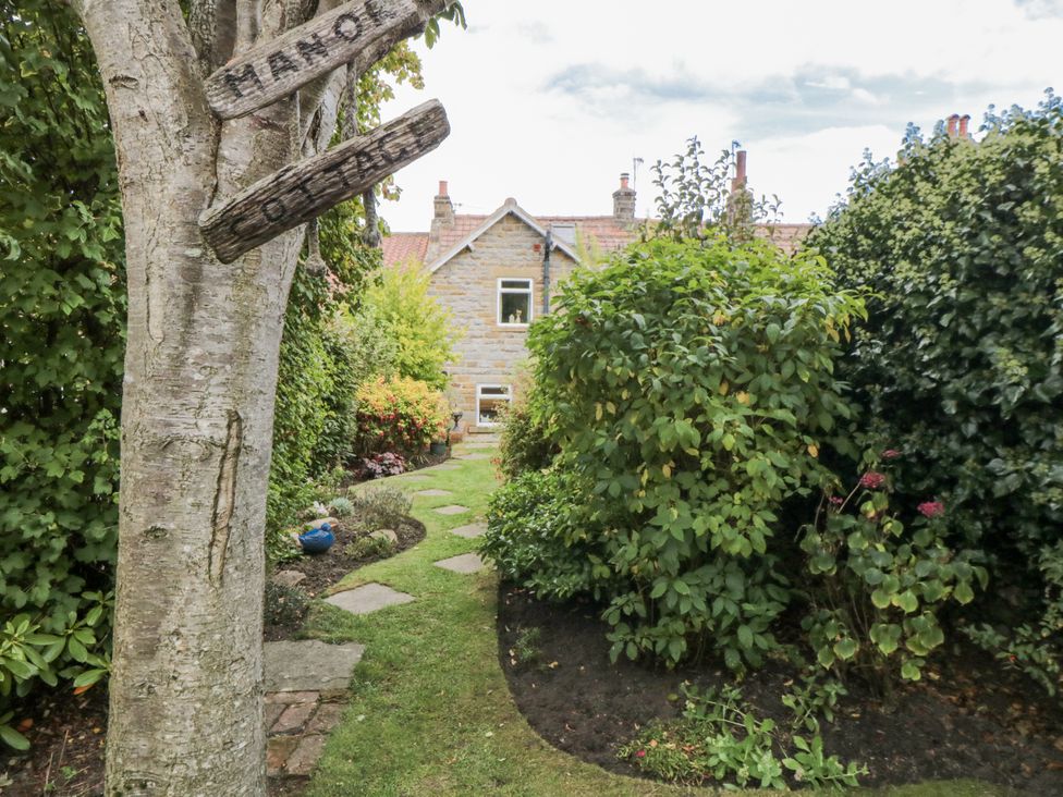 A garden with a pathway leading to a house at 21 High Street, Scarborough