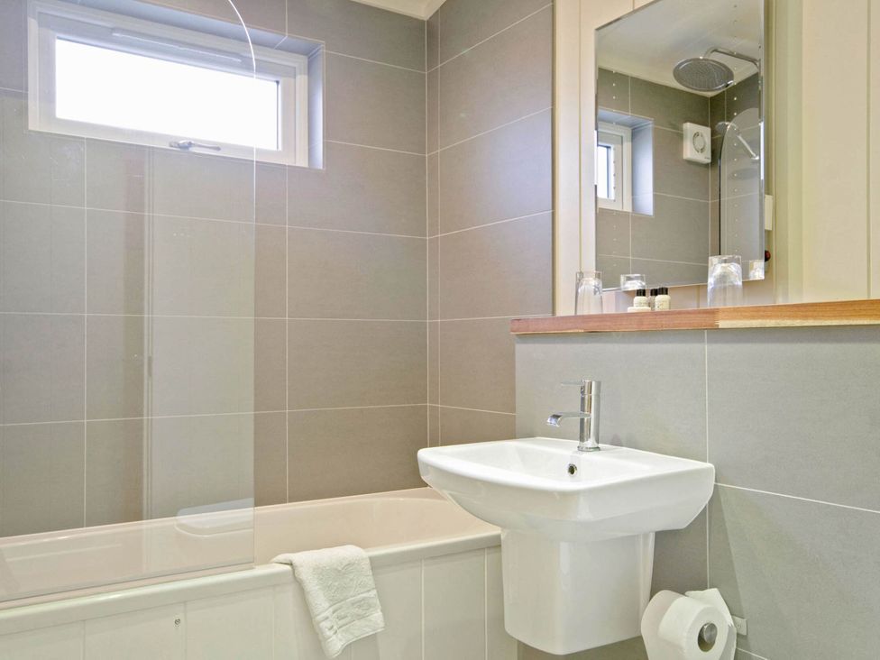 A bathroom with a bathtub, sink, and toilet at Lawson in Wigton