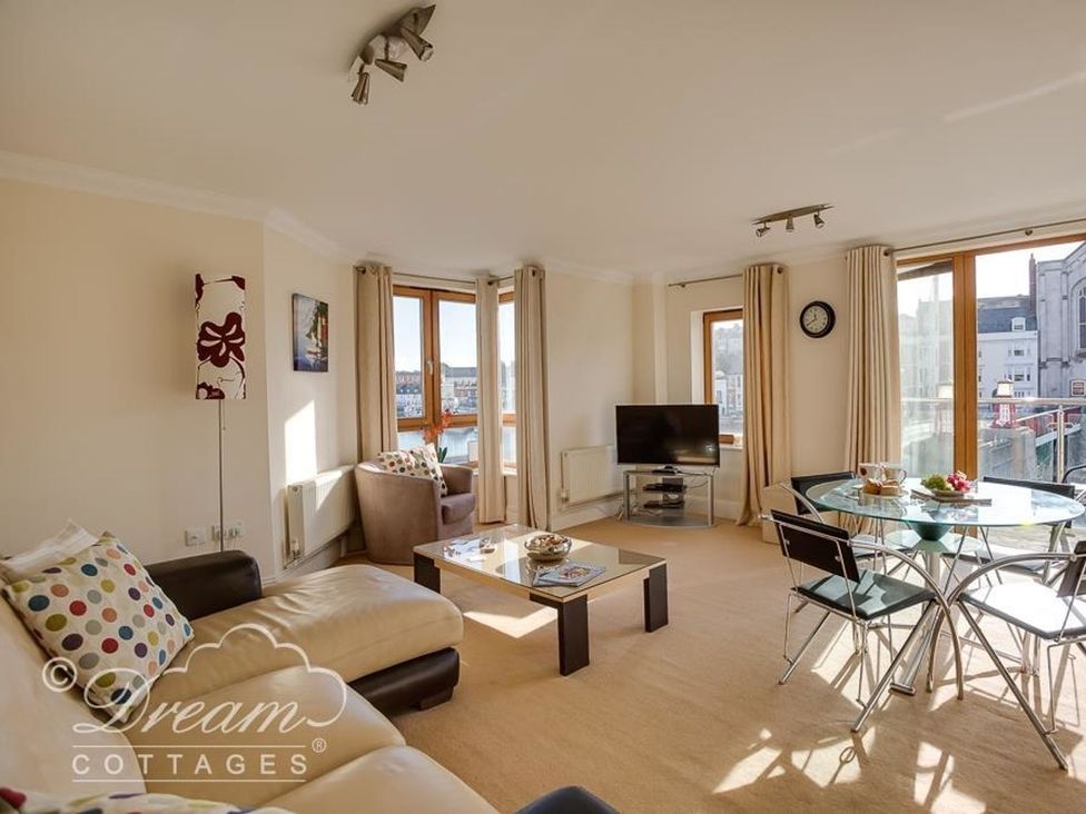 A living room with a sofa and a table at Harbourside Apartment in Weymouth
