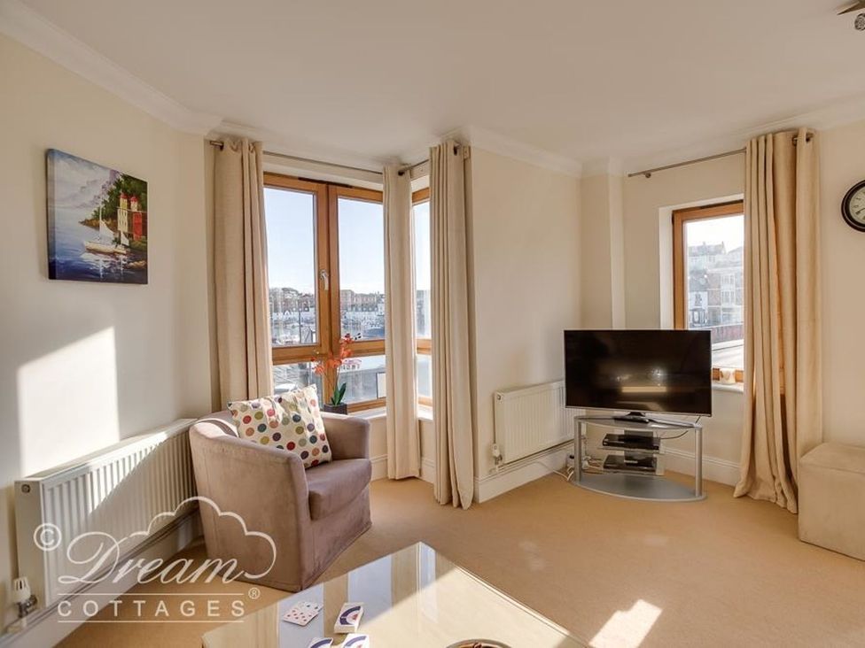 A living room with a sofa and television at Harbourside Apartment in Weymouth