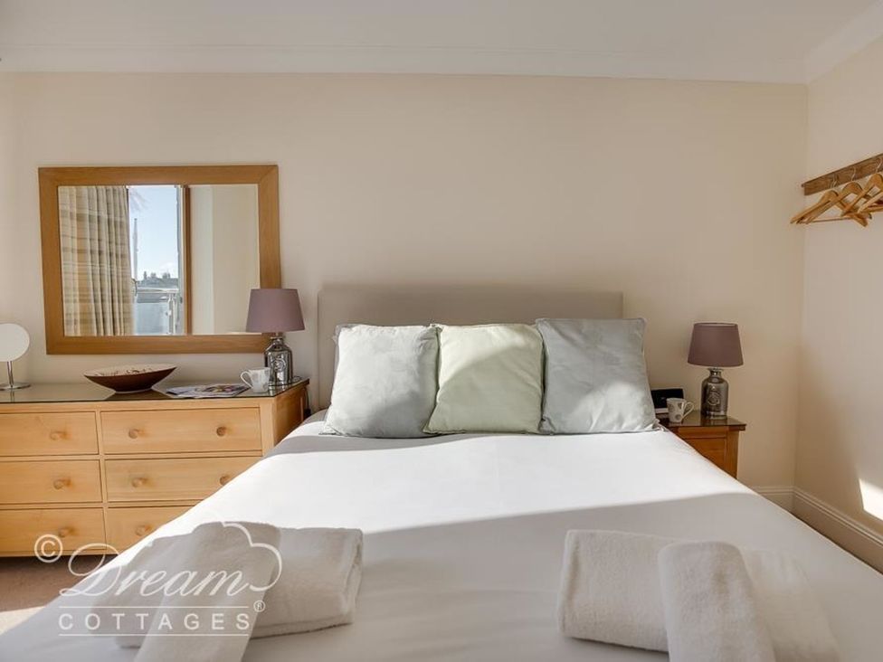 A bedroom with a bed and dresser at Harbourside Apartment in Weymouth
