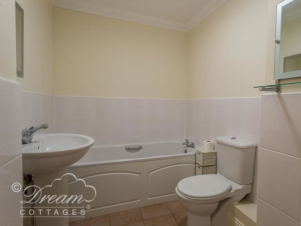 A bathroom with a bathtub, sink, and toilet at Harbourside Apartment in Weymouth