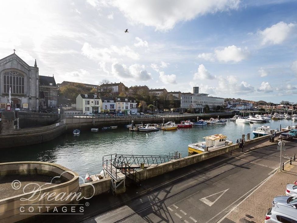 View of boats and buildings by water at Harbourside Apartment in Weymouth