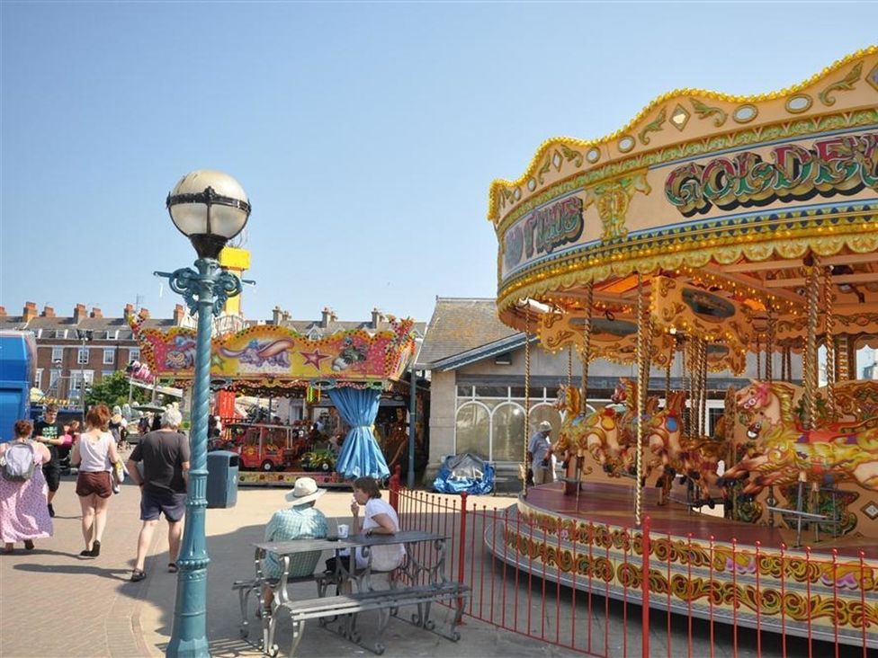 A carousel and people at a carnival area at Harbourside Apartment in Weymouth