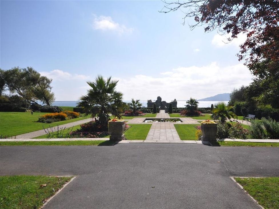 A garden with flowers and pathways at Harbourside Apartment in Weymouth