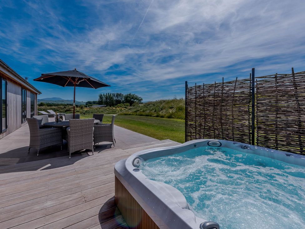 An outdoor area with a hot tub and dining table at Wellington in Wigton