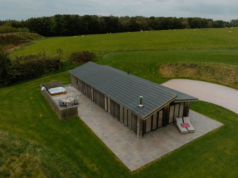 A hut with a hot tub and patio furniture at Wellington in Wigton