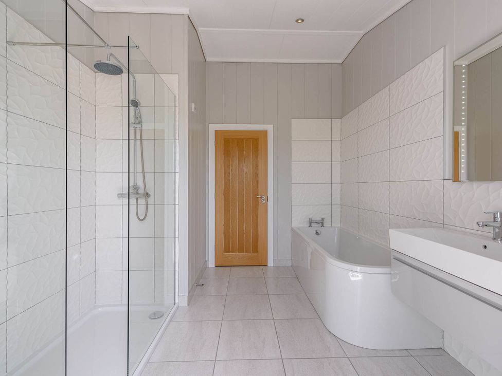 A bathroom with a shower and bathtub at Wellington in Wigton