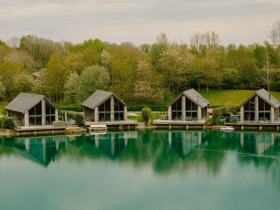 Three cabins reflected in water at Wellington in Aspatria