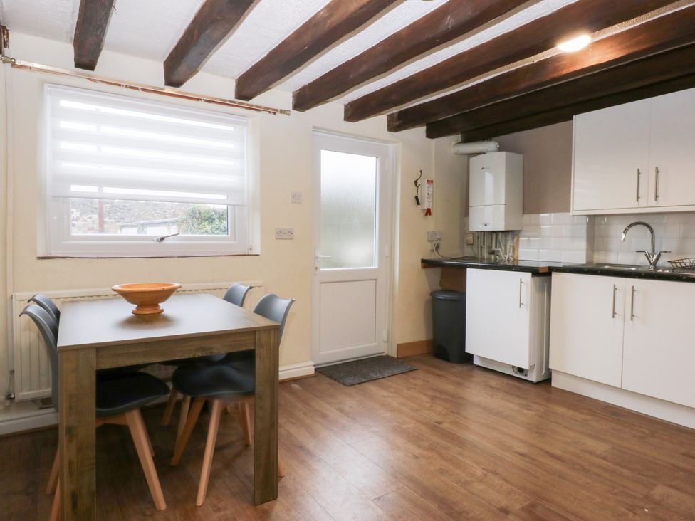 A kitchen with a table and chairs at 6 Berry Street in Conwy