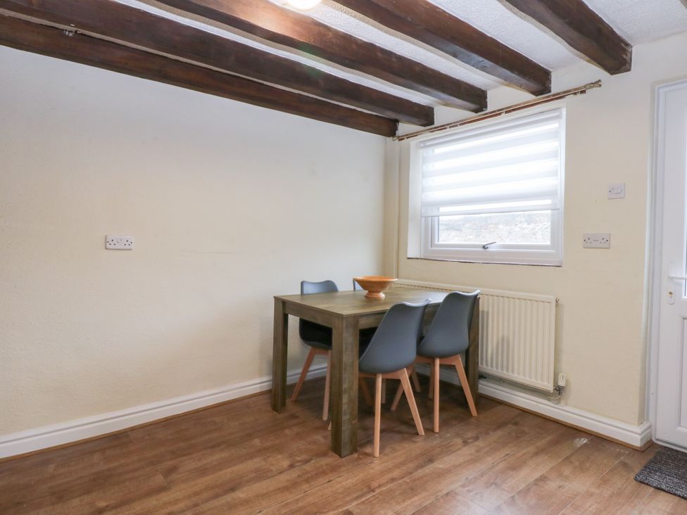 A dining room with a table and chairs at 6 Berry Street Conwy