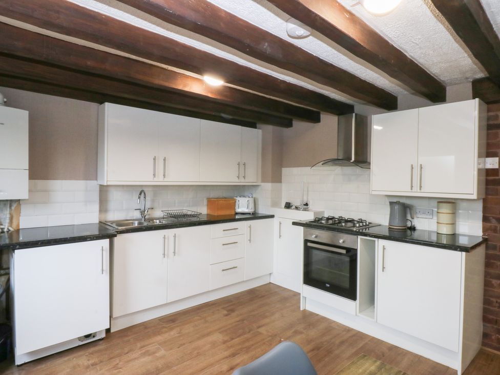 A kitchen with cabinets and appliances at 6 Berry Street in Conwy