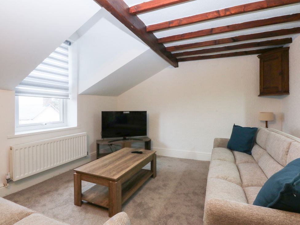 A living room with sofa and television at 6 Berry Street Conwy