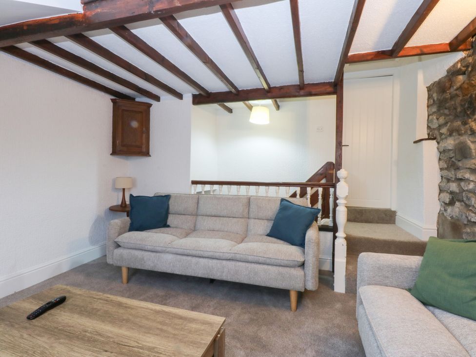 A living room with a sofa and wooden beams at 6 Berry Street in Conwy