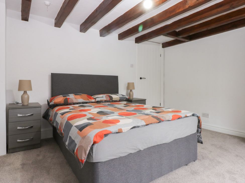 A bedroom with a bed and nightstand at 6 Berry Street in Conwy