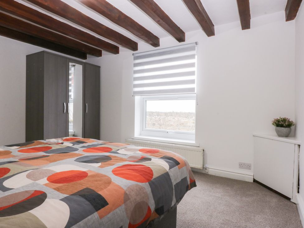 A bedroom with a bed and wardrobe at 6 Berry Street in Conwy