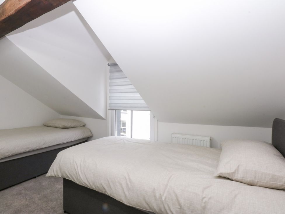 A bedroom with two beds and a window at 6 Berry Street in Conwy