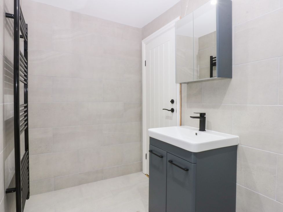 A bathroom featuring a vanity with a sink and a mirror at 6 Berry Street in Conwy