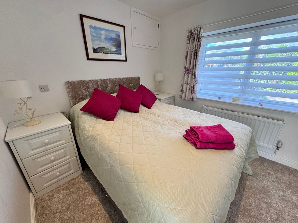 A bedroom with a bed and bedside tables at Ty Nain in Bodorgan