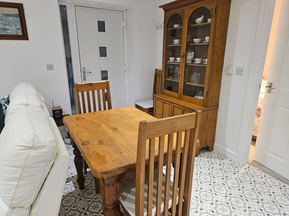 A dining room featuring a wooden table and chairs at Ty Nain in Bodorgan