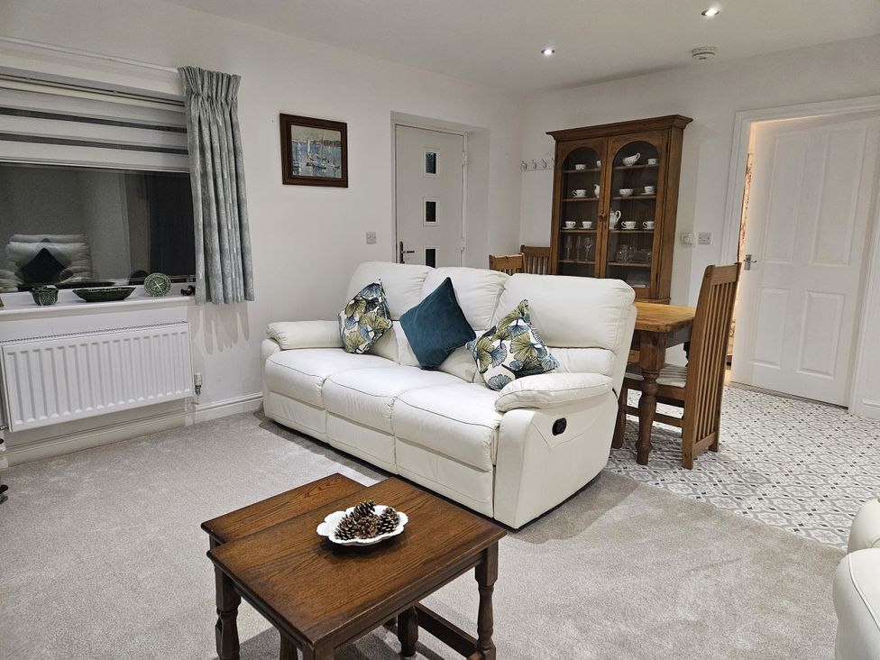 A living room with a sofa and table at Ty Nain in Bethel