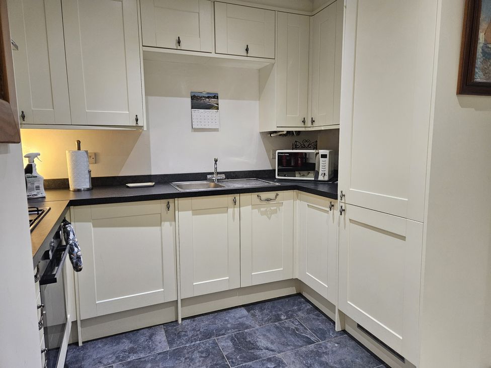 A kitchen with a sink and microwave at Ty Nain Bethel
