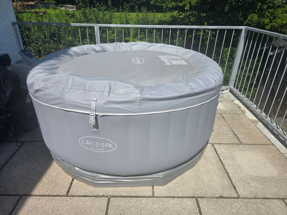 A hot tub with a cover on decking at Ty Nain in Bethel