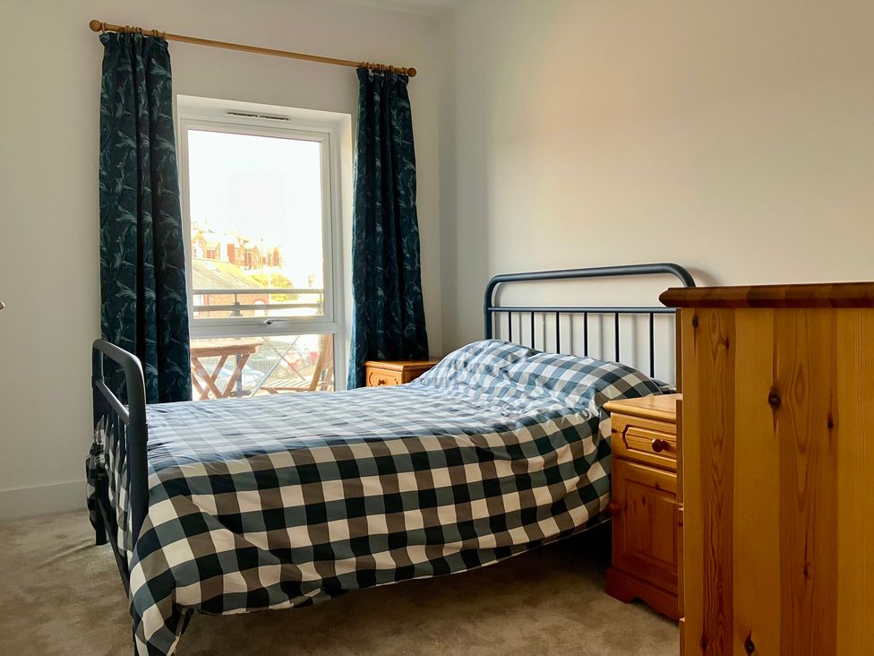 A bedroom with a bed and side tables at 12 Brewhouse Place in Weymouth
